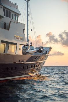 a large boat in the ocean at sunset