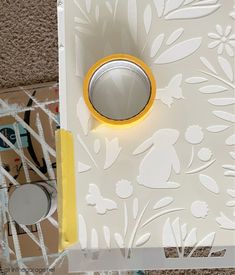 a yellow tape is taped to the side of a white box with flowers on it