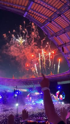 fireworks are lit up in the sky above an arena