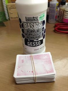 a stack of playing cards sitting on top of a table next to a bottle of glue