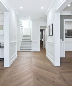 an empty room with white walls and wood floors is seen in this image from the entry way