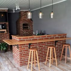 a brick bar with three stools next to it