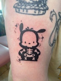 a person with a tattoo on their arm and the image of a rabbit holding a cake