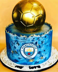 a blue cake with a gold soccer ball on top