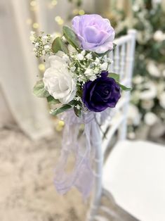 purple and white flowers in a vase on a chair