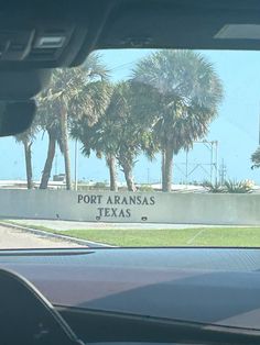 there is a sign that says port arasas on the side of a road with palm trees