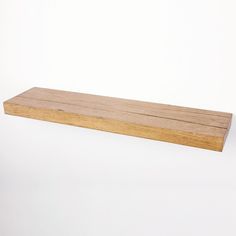 a wooden shelf sitting on top of a white wall