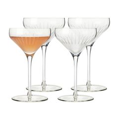 four wine glasses with different colored liquids in them