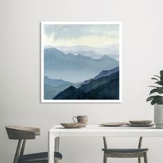 a table with two chairs and a painting on the wall above it that has mountains in the background