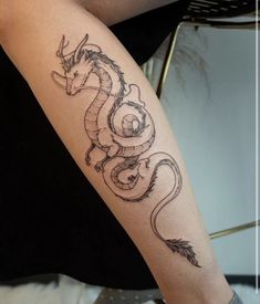 a woman's arm with a dragon tattoo on the left side of her body