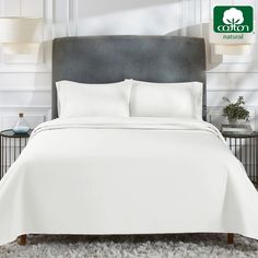 a bed with white sheets and pillows in a room