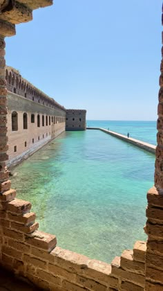 an open window looking out at the water and brick walls that have been built into it