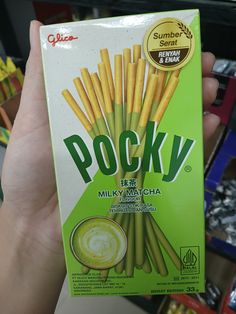 a person holding up a box of pocky milk matcha sticks in their hand