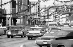 an old black and white photo of cars on a city street