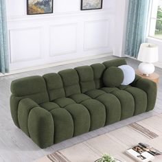 a large green couch sitting on top of a hard wood floor