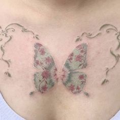 a woman's chest with a butterfly tattoo on the top and bottom part of her breast