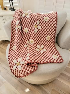 a red and white blanket sitting on top of a chair