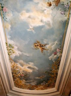 an ornate painted ceiling with birds and flowers in the sky, above it is a cat