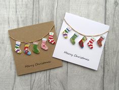 two christmas cards with stockings hanging from them