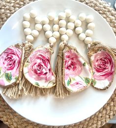 four pieces of porcelain sitting on top of a white plate next to beads and flowers