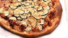 a pizza with zucchini and other toppings on it