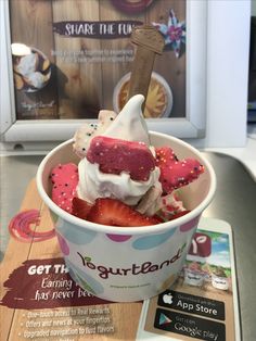 an ice cream sundae with strawberries and sprinkles in a bowl