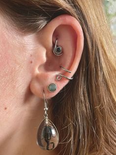 a close up of a person with ear piercings on their ears and behind the ear