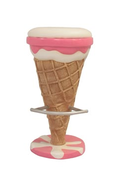 an ice cream cone with pink and white icing sitting on top of a stand