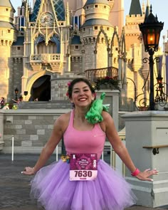 a woman in a pink and purple dress is posing for a photo at disney world