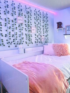 there is a bed with pink sheets and pillows in the room that has ivys on the wall