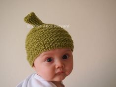 a baby wearing a green knitted hat