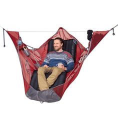 a man laying in a hammock with his feet on the ground