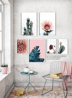 a chair and table in a room with pictures on the wall above it, along with a potted plant