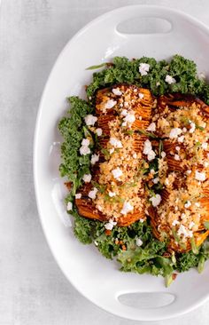 a white plate topped with lettuce covered in feta and other toppings