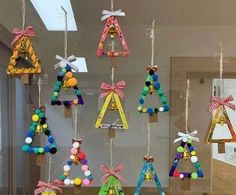 a group of colorful wooden ornaments hanging from hooks on a wall in front of a mirror