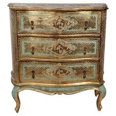 an ornately decorated chest of drawers with gold and blue paint on the top,