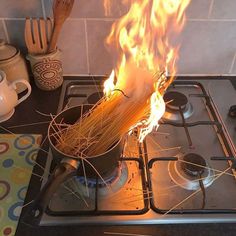 a pot on the stove is full of spaghetti and flames as if it were being cooked