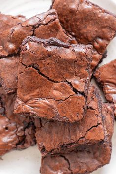 chocolate brownies stacked on top of each other in a white plate with one bite taken out