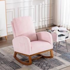 a pink rocking chair sitting on top of a rug