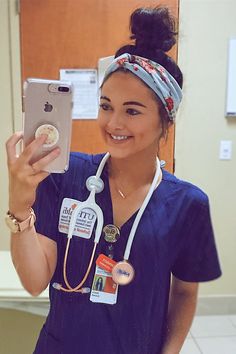 a woman in scrubs taking a selfie with her cell phone and wearing a headband