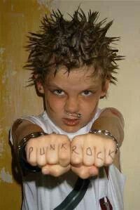 a young boy with spiked hair holding his hands in front of him and pointing at the camera