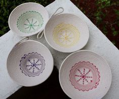 four woven baskets sitting on top of a cement block