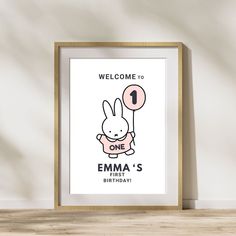 a wooden frame with a cartoon bunny holding a balloon and the words welcome to one emma's first birthday