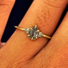 a woman's hand with a yellow gold ring on it and a brown diamond in the middle