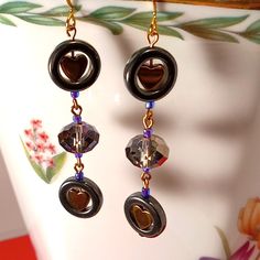 These Gorgeous Heart & Hematite Earrings Are Handcrafted W/Color Shift Crystal Rondelles-When The Light Reflects Off Of The Smokey Faceted Crystal Rondelles It Is Absolutely Stunning! New! One-Of-A-Kind! 1 Pr. All Jewelry In Boutique Are My Designs. They Are One-Of-A-Kind! I've Been Making & Designing Jewelry For36+ Yrs & Been An Artist From The Moment I Was Given My First Box Of Crayons As A Child! I Redesign Furniture, Wrought Iron, & Other Items To Breathe New Life Into Them! I Love What I Do Redesign Furniture, Hematite Earrings, Designing Jewelry, Box Of Crayons, Hematite Jewelry, Smoky Crystal, Themed Jewelry, Faceted Crystal, Heart Beads