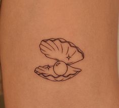 a woman's stomach with a small tattoo of a shell and an apple on it