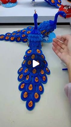 a person is making a peacock decoration