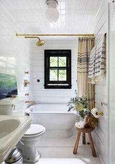 a bathroom with a toilet, sink, and bathtub in white tile flooring