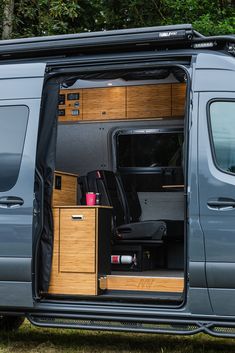 the interior of a van with its doors open and furniture in it's compartment