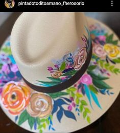 a white hat with flowers painted on it